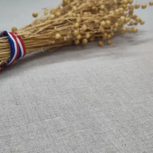Bouquet de lin français avec ruban tricolore posé sur tissu de lin brut, matière naturelle pour marmite norvégienne