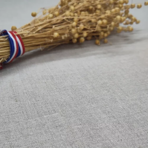 Bouquet de lin français avec ruban tricolore posé sur tissu de lin brut, matière naturelle pour marmite norvégienne