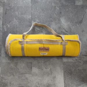 Tapis de yoga en laine et lin de couleur jaune, roulé avec sangle intégrée