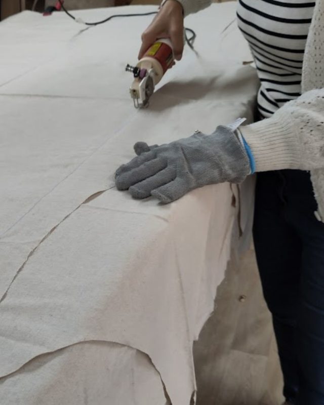 Découpe du tissu en lin dans l’atelier Ecocotte pour la fabrication de marmites norvégiennes