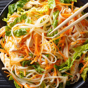 Nouilles asiatiques sautées avec carottes, salade et légumes